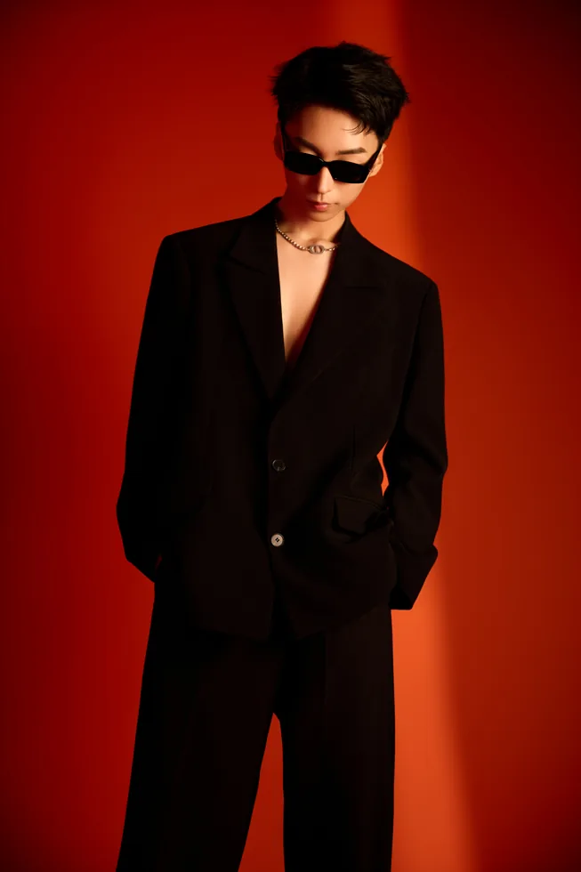 Black suit and sunglasses portrait of ZGY against red
