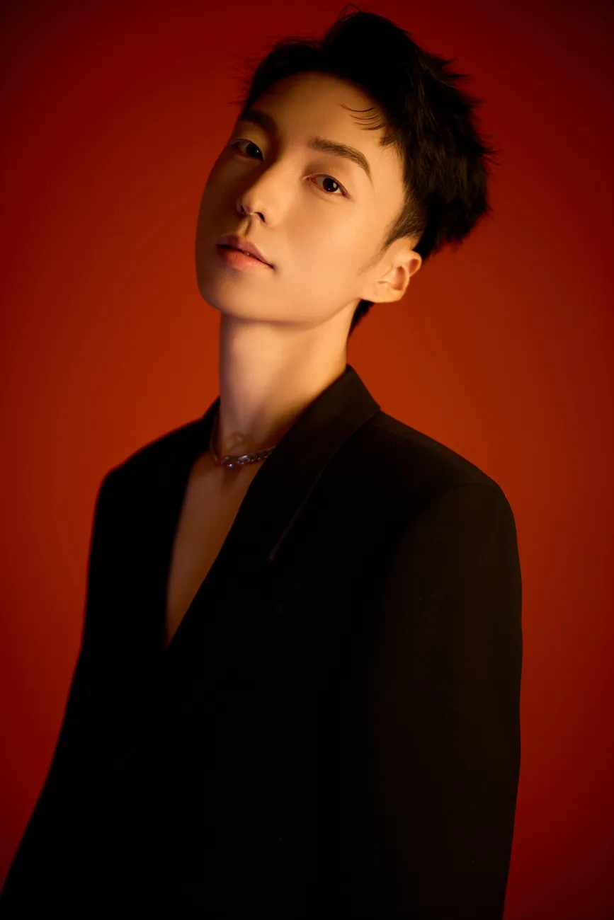 Half-length black suit portrait of ZGY against red
